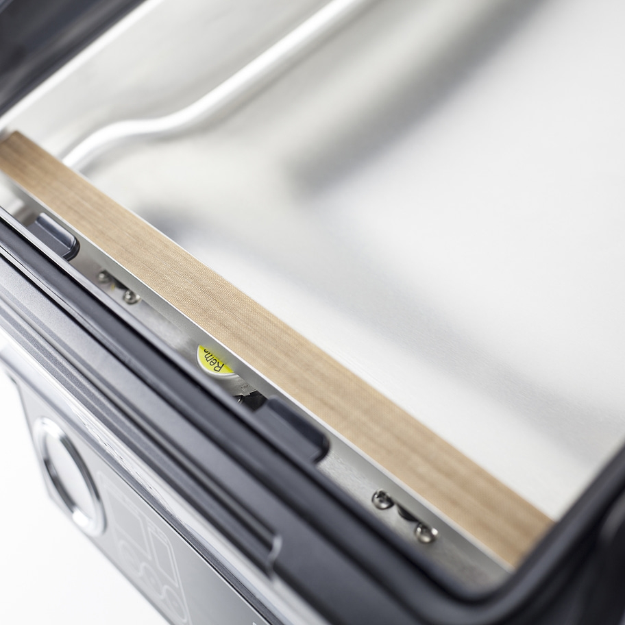 Nahaufnahme eines Vakuumiergeräts mit braunem Siegelband und Metalloberfläche.