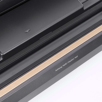 Nahaufnahme eines Geräts mit Warnhinweis: Achtung: Heiß! / Caution: Hot!