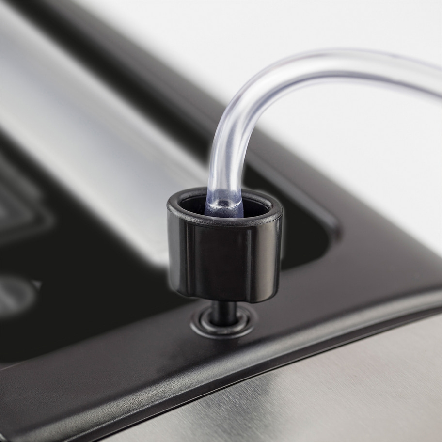 Nahaufnahme eines schwarzen Kunststoffteils mit einem durchsichtigen Schlauch, der in ihn eingesetzt ist.