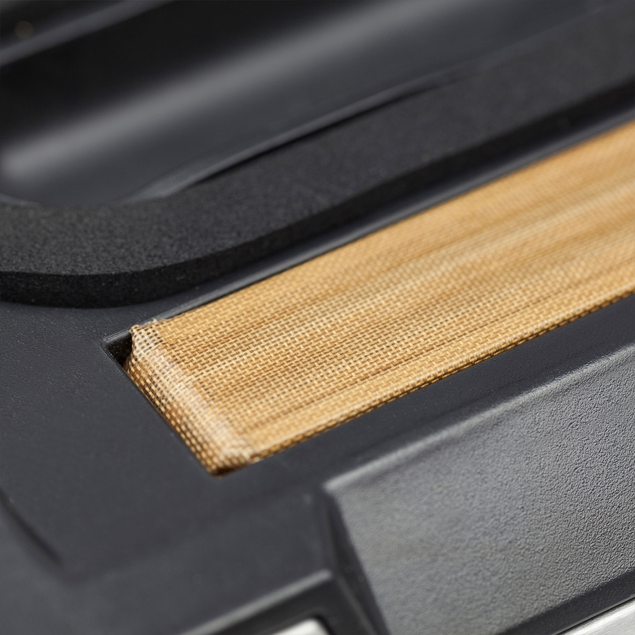 Nahaufnahme eines schwarzen Geräts mit braunem Stoff und schwarzem Schaumstoff