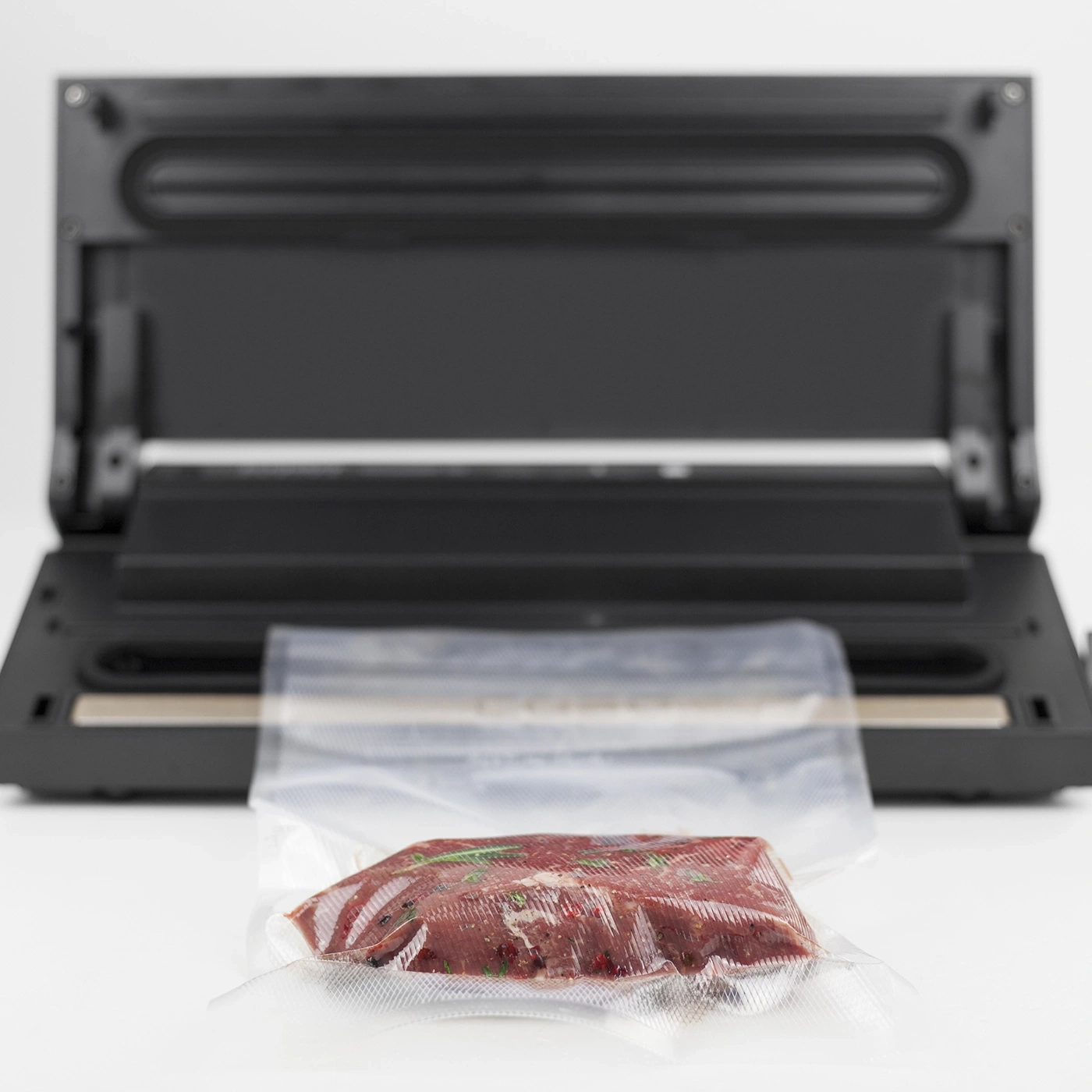 Fleisch in Vakuumverpackung vor Vakuumiergerät. Lebensmittelkonservierung.