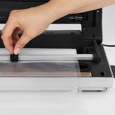 Hand bedient Vakuumiergerät, Folie wird fixiert, Detailaufnahme, Nahaufnahme, Technik