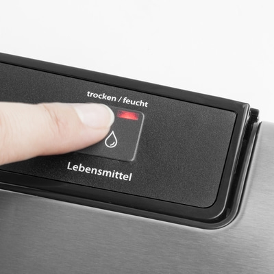Hand drückt Knopf mit der Aufschrift 'trocken/feucht' und einem Wassertropfen-Symbol