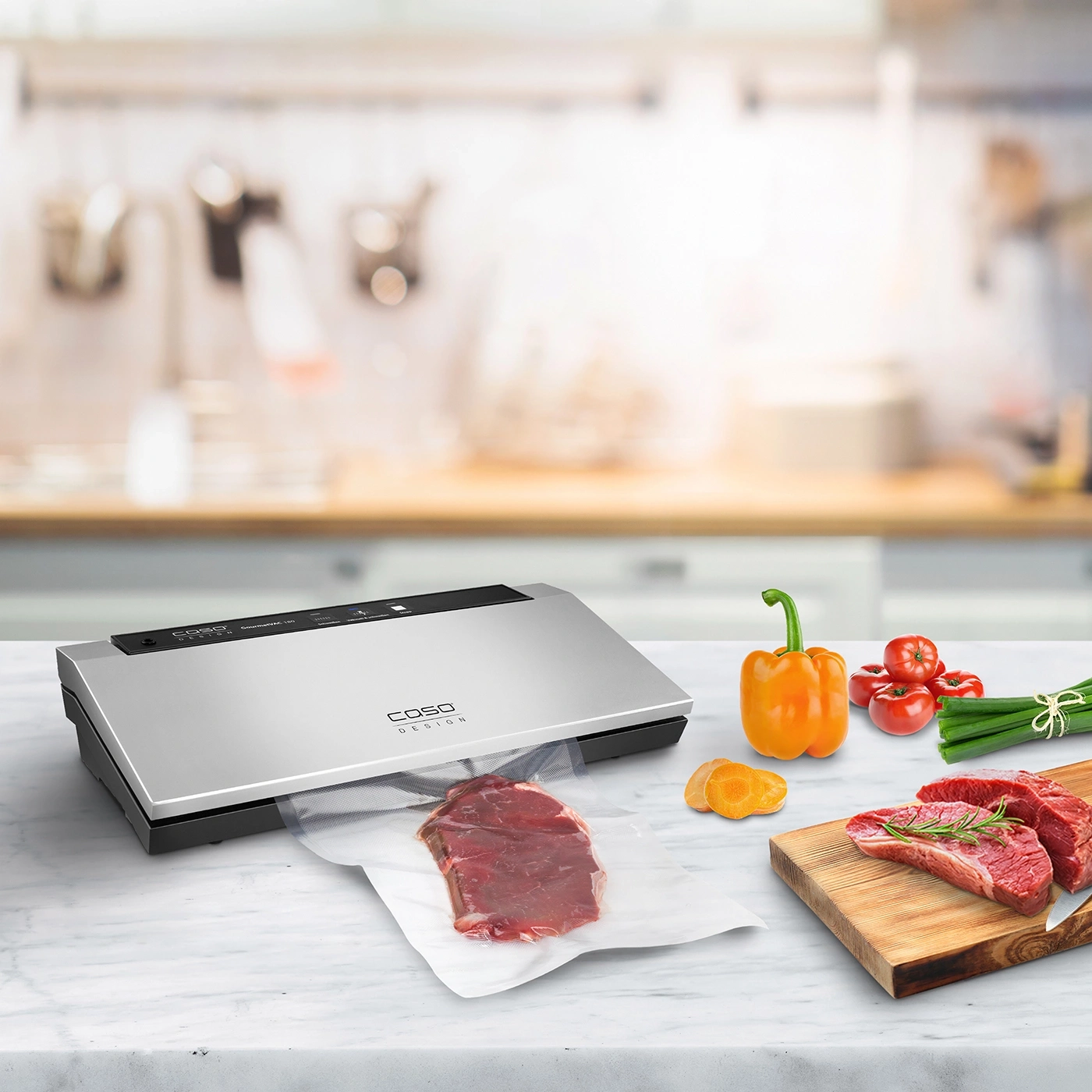Vakuumiergerät mit Fleisch und Gemüse auf einer Küchenarbeitsplatte