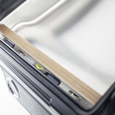 Nahaufnahme eines Vakuumiergeräts mit braunem Siegelband und Metalloberfläche.