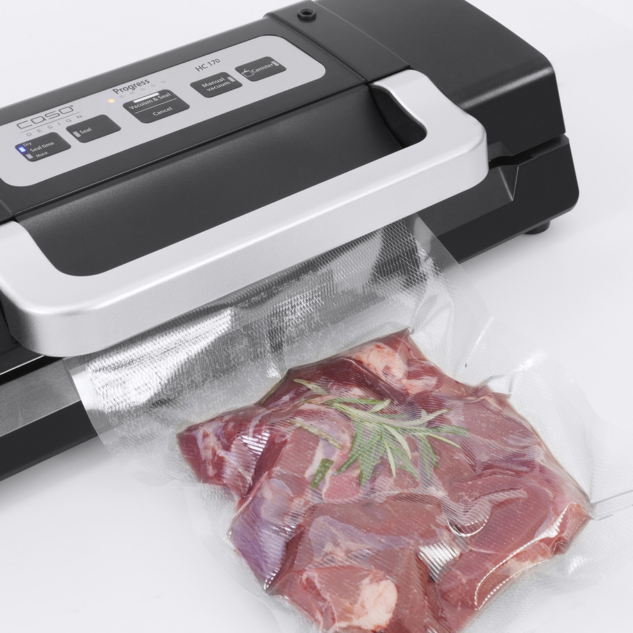 Vakuumiergerät mit Fleisch in einer Tüte, bereit zum Versiegeln. Caso Design.