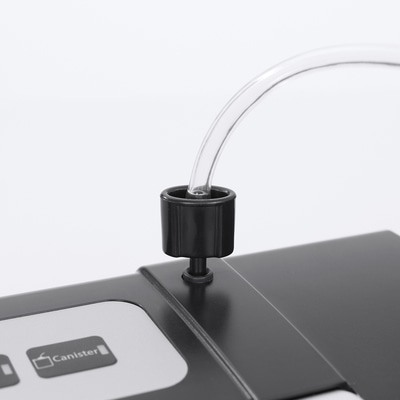 Nahaufnahme eines schwarzen Geräts mit einem Schlauch und der Aufschrift 'Canister'.