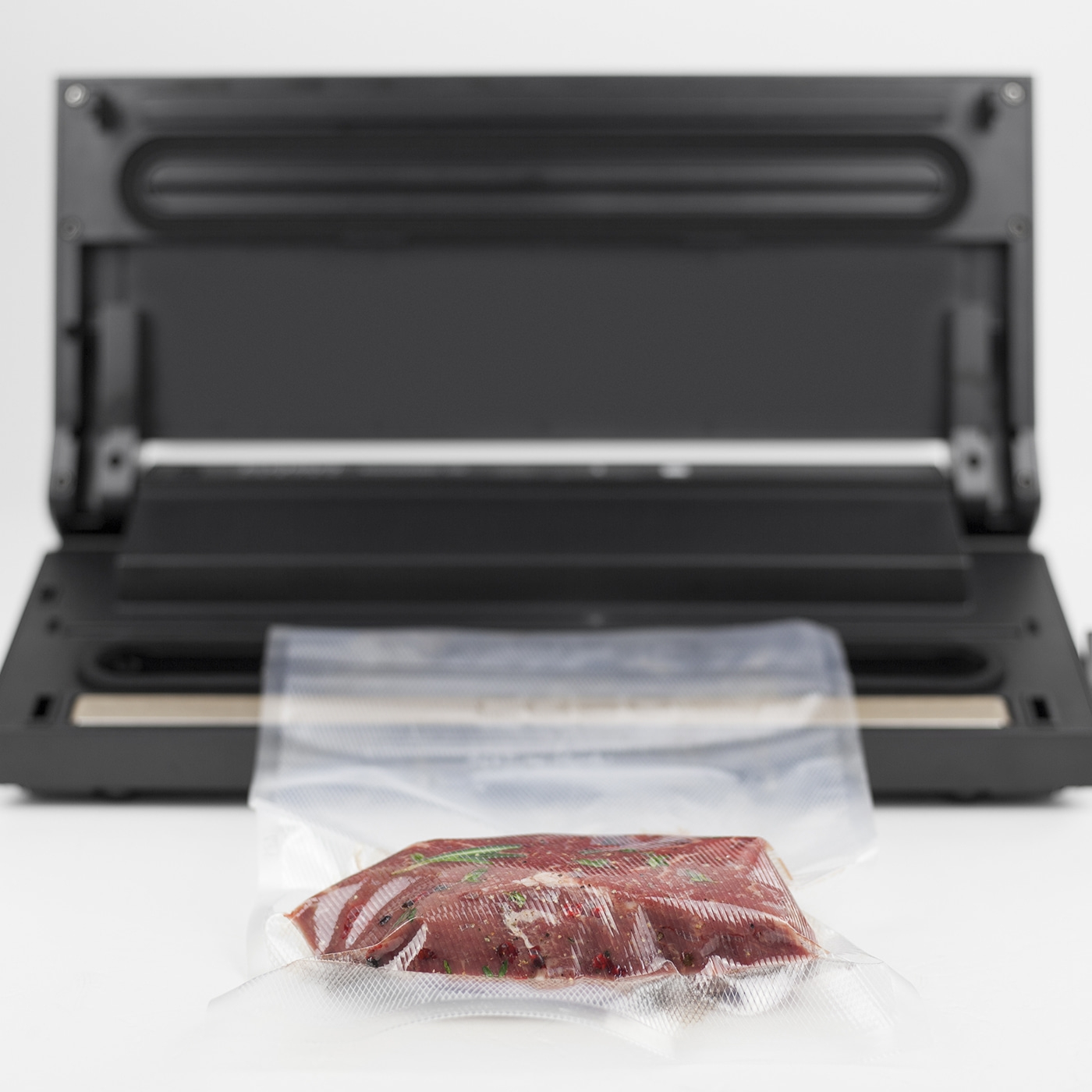 Fleisch in Vakuumverpackung vor Vakuumiergerät. Lebensmittelkonservierung.