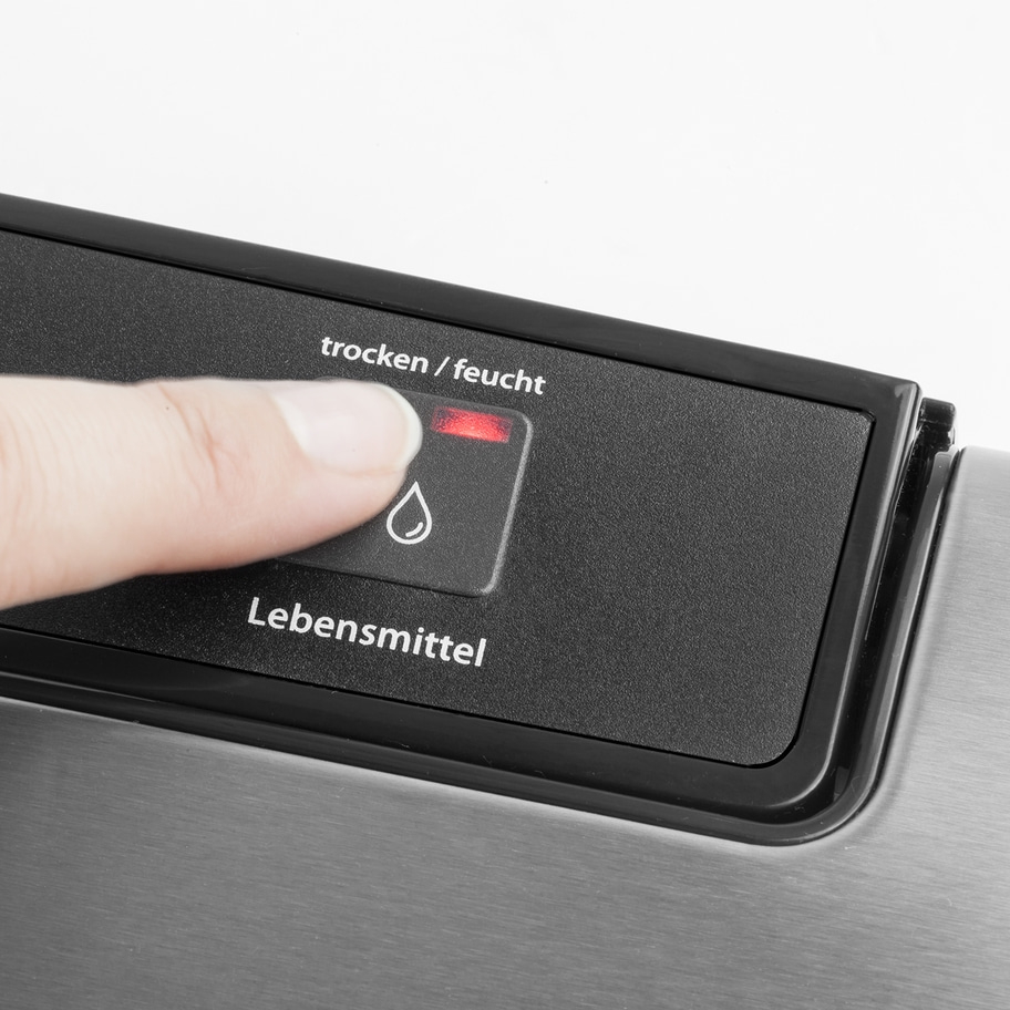 Hand drückt Knopf mit der Aufschrift 'trocken/feucht' und einem Wassertropfen-Symbol