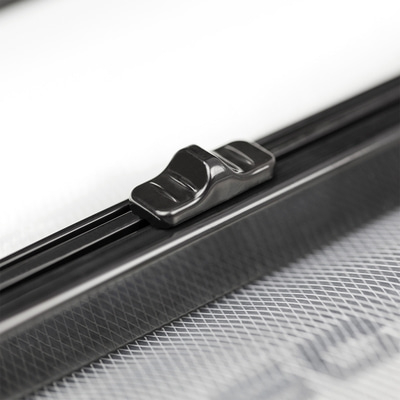 Nahaufnahme eines schwarzen Schiebereglers auf einem Fenstergitter mit weißem Hintergrund.