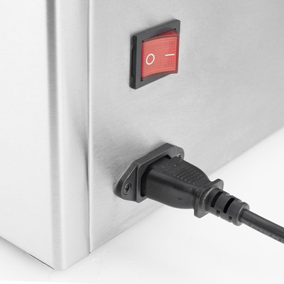 Ein roter Schalter und ein schwarzes Netzkabel an einem Metallgehäuse.