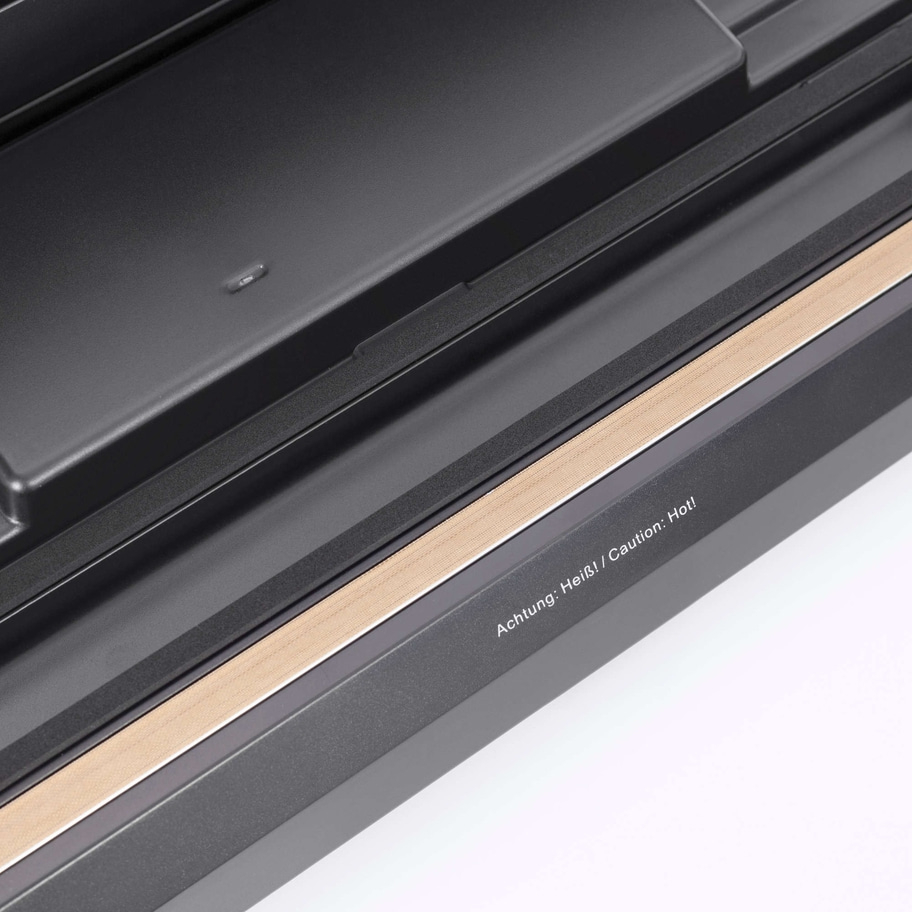 Nahaufnahme eines Geräts mit Warnhinweis: Achtung: Heiß! / Caution: Hot!